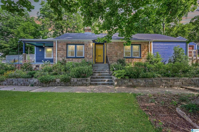 5100 7th Ct S, Birmingham, AL 35212 - view of front facade with stone siding, a front lawn, and a chimney