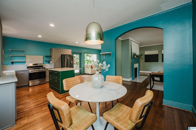 5100 7th Ct S, Birmingham, AL 35212 - dining area featuring arched walkways, a large fireplace, wood finished floors, and recessed lighting