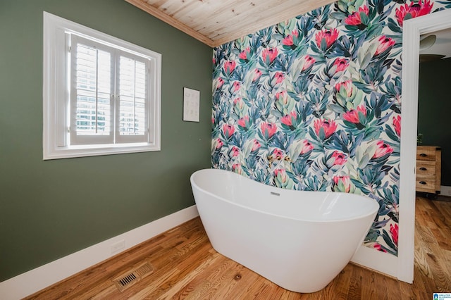 5100 7th Ct S, Birmingham, AL 35212 - bathroom featuring a freestanding bath, wood finished floors, and ornamental molding
