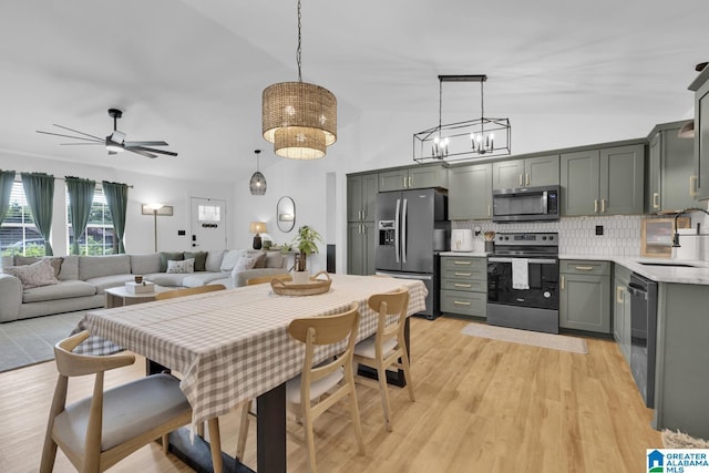6400 Glenview Cir, Gardendale, AL 35071 - kitchen with stainless steel appliances, decorative backsplash, light countertops, vaulted ceiling, and decorative light fixtures
