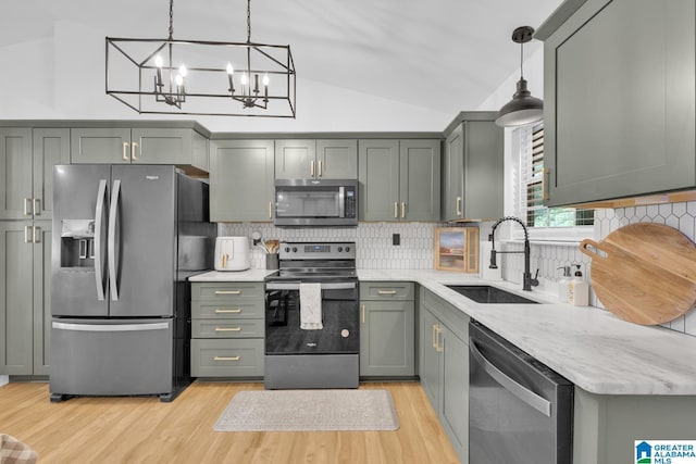 6400 Glenview Cir, Gardendale, AL 35071 - kitchen with stainless steel appliances, lofted ceiling, light wood finished floors, a chandelier, and backsplash