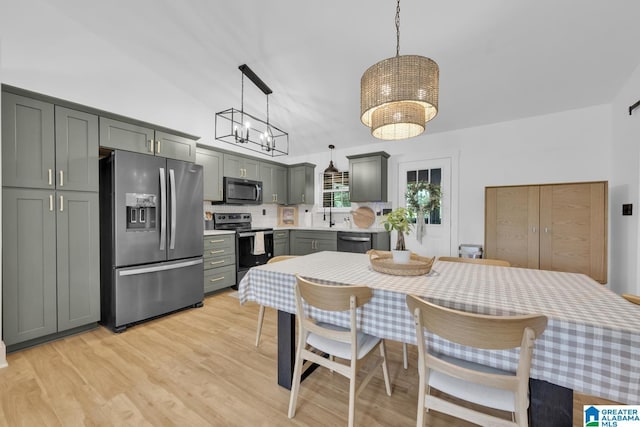 6400 Glenview Cir, Gardendale, AL 35071 - dining room with a chandelier, light wood-style floors, and high vaulted ceiling