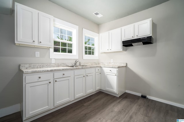 2129 Pike Rd, Birmingham, AL 35218 - kitchen with under cabinet range hood, dark wood-type flooring, and white cabinetry