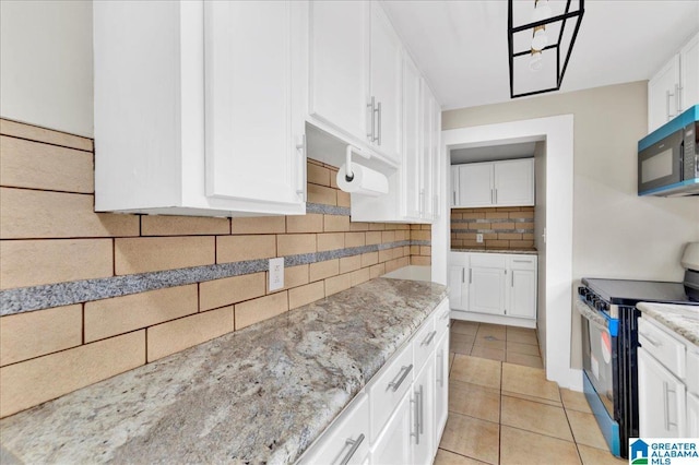 1125 SW 15th St, Birmingham, AL 35211 - kitchen featuring black appliances, tasteful backsplash, white cabinets, light stone countertops, and light tile patterned floors