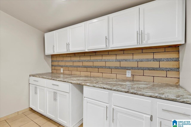 1125 SW 15th St, Birmingham, AL 35211 - kitchen with tasteful backsplash, white cabinetry, and light tile patterned floors