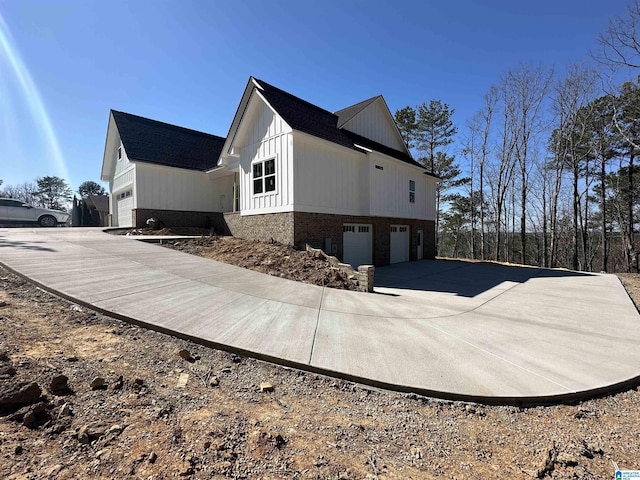 7733 Springer Rd, Mccalla, AL 35111 - view of side of home featuring a garage, concrete driveway, and roof with shingles