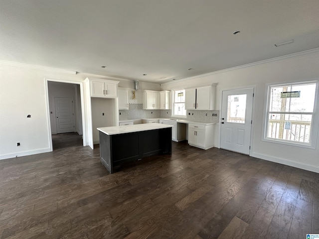7733 Springer Rd, Mccalla, AL 35111 - kitchen featuring ornamental molding, a kitchen island, dark wood-type flooring, white cabinetry, and backsplash