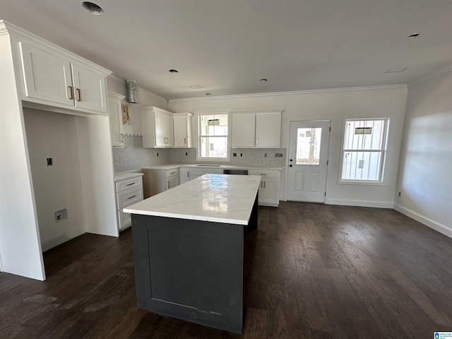 7733 Springer Rd, Mccalla, AL 35111 - kitchen featuring crown molding, a center island, white cabinetry, dark wood-style flooring, and backsplash