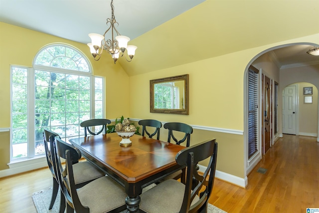 8587 Hayes Rd, Helena, AL 35022 - dining space featuring arched walkways, a chandelier, light wood finished floors, crown molding, and lofted ceiling