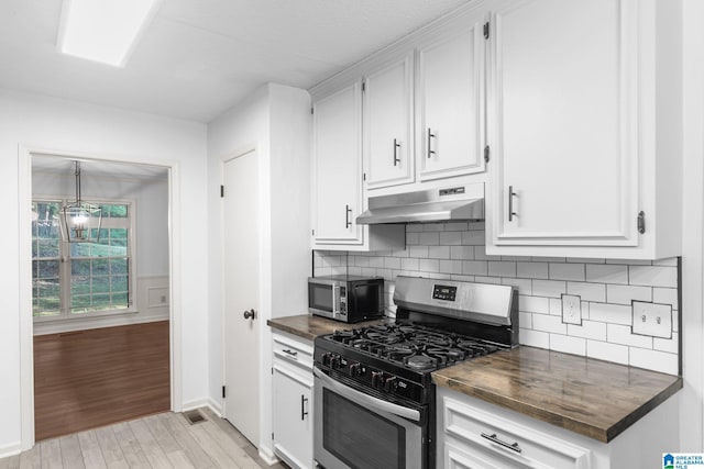 2005 Crossvine Rd, Hoover, AL 35244 - kitchen with appliances with stainless steel finishes, under cabinet range hood, light wood-style floors, white cabinets, and decorative backsplash