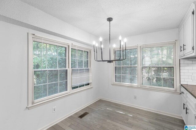 2005 Crossvine Rd, Hoover, AL 35244 - unfurnished dining area featuring a chandelier, light wood finished floors, and a textured ceiling