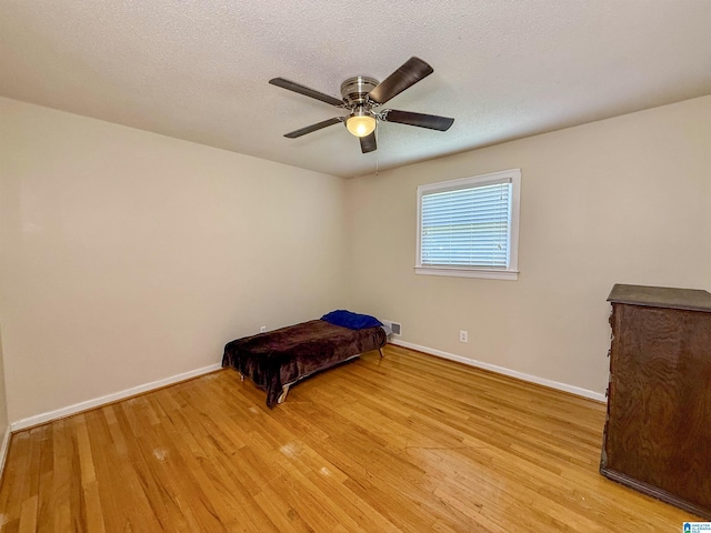 1027 Creek Trl, Anniston, AL 36206 - unfurnished bedroom featuring light wood-style flooring, a ceiling fan, and a textured ceiling