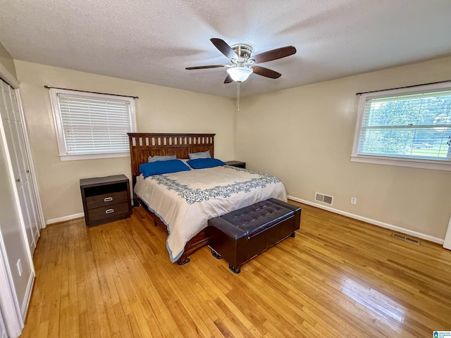 1027 Creek Trl, Anniston, AL 36206 - bedroom with light wood finished floors, a textured ceiling, and a ceiling fan