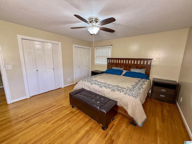 1027 Creek Trl, Anniston, AL 36206 - bedroom with light wood-style floors, two closets, a textured ceiling, and ceiling fan