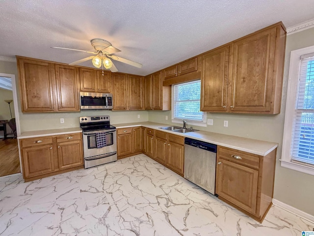 1027 Creek Trl, Anniston, AL 36206 - kitchen featuring stainless steel appliances, ceiling fan, light marble finish flooring, brown cabinetry, and light countertops
