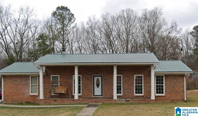 935 W 42nd St, Anniston, AL 36206 - single story home with a front yard, a metal roof, brick siding, and covered porch