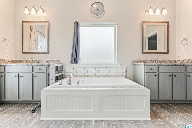 4486 Old Cahaba Pkwy, Helena, AL 35080 - bathroom featuring wood finish floors, two vanities, and a bath