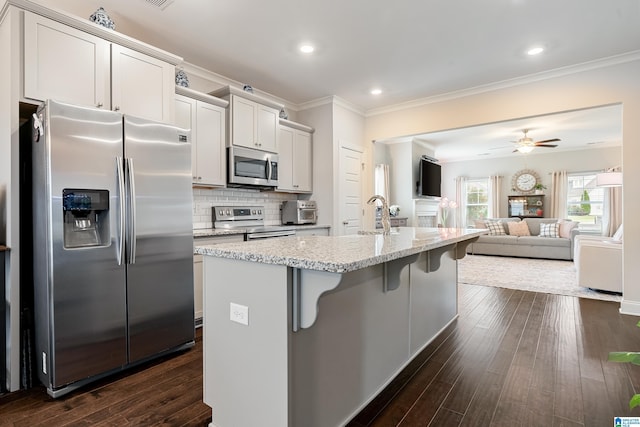4486 Old Cahaba Pkwy, Helena, AL 35080 - kitchen with stainless steel appliances, crown molding, open floor plan, a breakfast bar area, and dark wood-style flooring