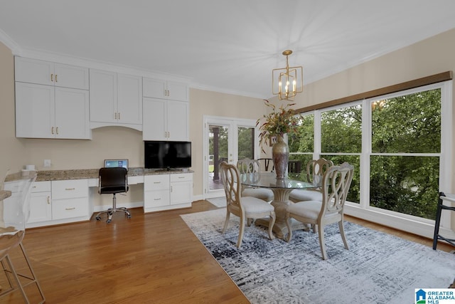 5557 Lakes Edge Dr, Hoover, AL 35242 - dining area with built in study area, wood finished floors, ornamental molding, french doors, and a chandelier