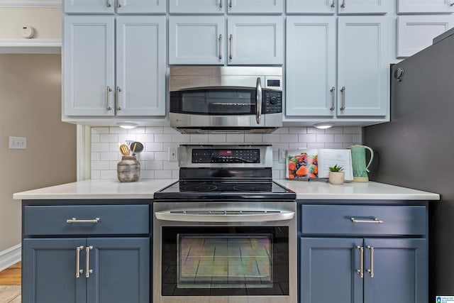 505 Waterside Cir, Mccalla, AL 35111 - kitchen featuring appliances with stainless steel finishes, light countertops, decorative backsplash, and blue cabinetry