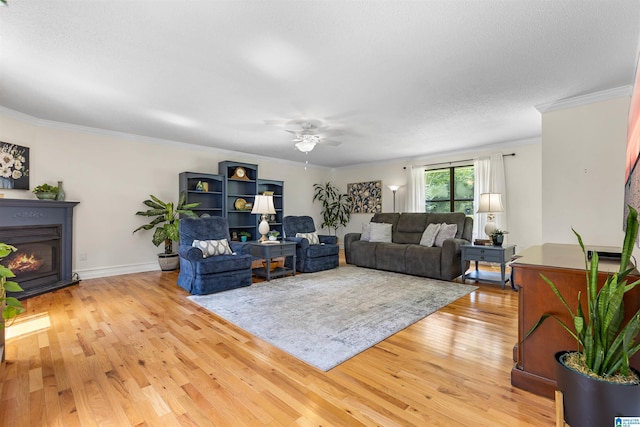 505 Waterside Cir, Mccalla, AL 35111 - living area featuring a ceiling fan, light wood finished floors, a glass covered fireplace, and crown molding