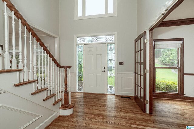 3357 Afton Ln, Birmingham, AL 35242 - foyer entrance featuring a towering ceiling, wood finished floors, plenty of natural light, wainscoting, and stairs