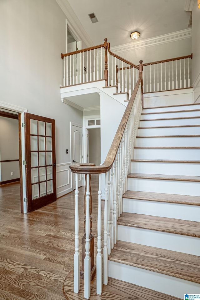 3357 Afton Ln, Birmingham, AL 35242 - staircase featuring crown molding, wood finished floors, a decorative wall, and a towering ceiling