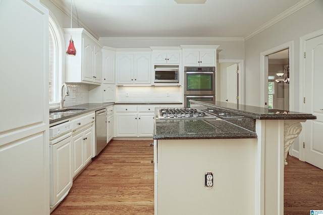 3357 Afton Ln, Birmingham, AL 35242 - kitchen featuring appliances with stainless steel finishes, light wood-style flooring, a center island, crown molding, and tasteful backsplash