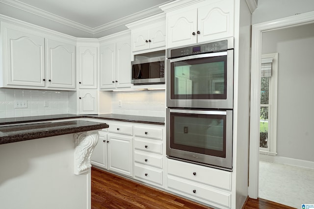 3357 Afton Ln, Birmingham, AL 35242 - kitchen with stainless steel appliances, dark countertops, white cabinets, tasteful backsplash, and dark wood-style flooring