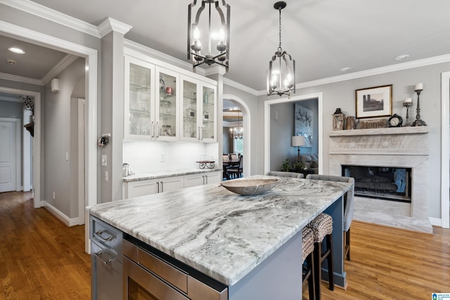 4067 Milners Cres, Hoover, AL 35242 - kitchen featuring a chandelier, arched walkways, light stone counters, white cabinetry, and light wood-type flooring