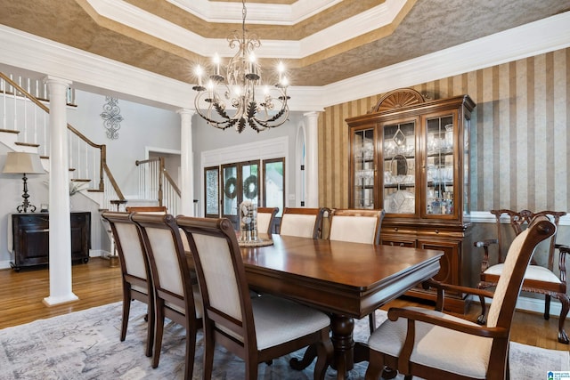 4067 Milners Cres, Hoover, AL 35242 - dining space featuring decorative columns, ornamental molding, wood finished floors, stairs, and a chandelier