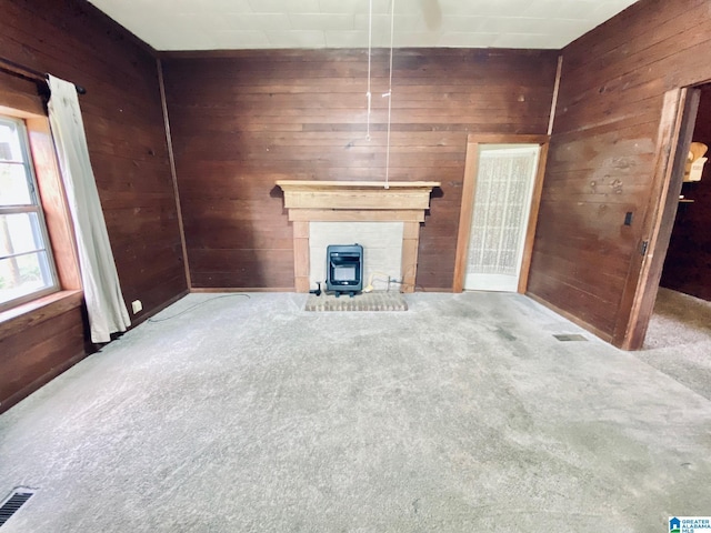 672 Websters Chapel Rd, Wellington, AL 36279 - unfurnished living room with wood walls, carpet, and a wood stove