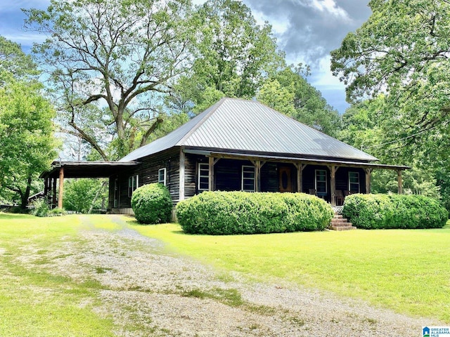 672 Websters Chapel Rd, Wellington, AL 36279 - view of side of property with covered porch, a lawn, driveway, an attached carport, and a metal roof
