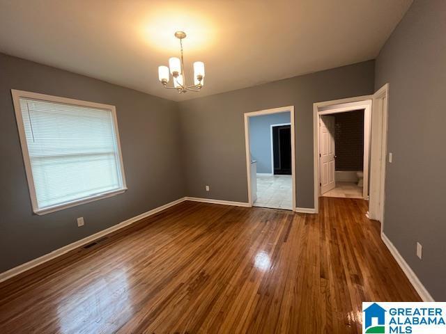 2732 29th St, Birmingham, AL 35208 - empty room featuring a chandelier and dark wood-style floors