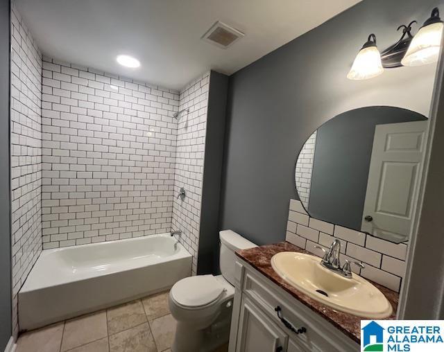 2732 29th St, Birmingham, AL 35208 - bathroom with vanity, tile patterned floors, washtub / shower combination, and tasteful backsplash