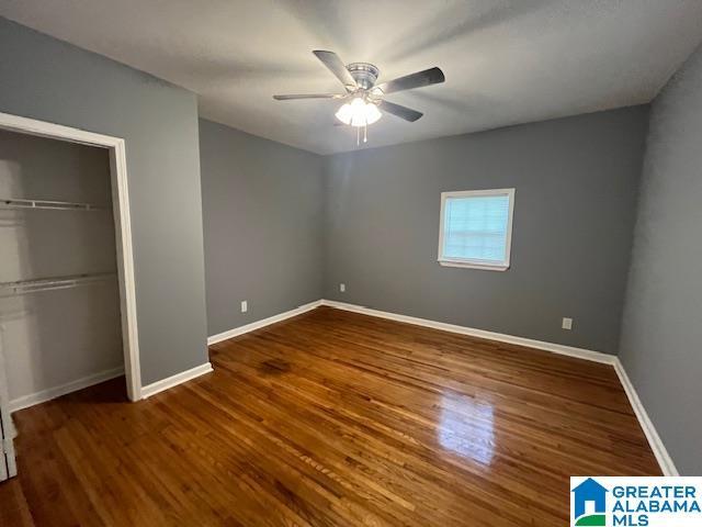 2732 29th St, Birmingham, AL 35208 - unfurnished bedroom with a closet, wood finished floors, and a ceiling fan