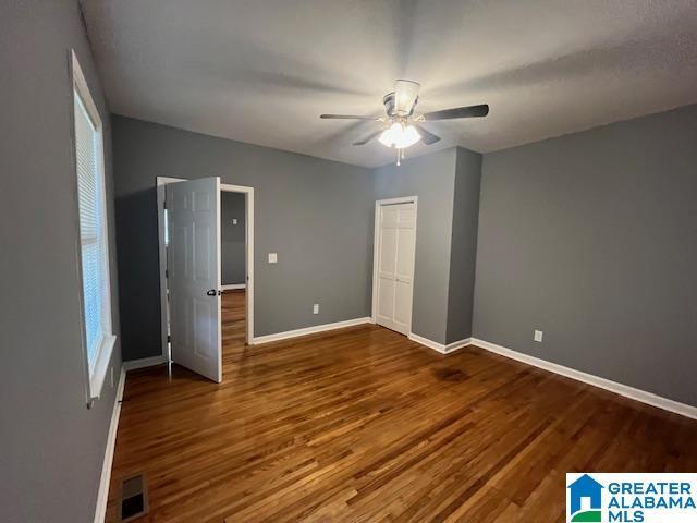 2732 29th St, Birmingham, AL 35208 - unfurnished bedroom featuring wood finished floors, ceiling fan, and a closet