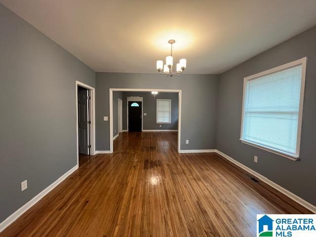 2732 29th St, Birmingham, AL 35208 - unfurnished dining area featuring a chandelier and wood finished floors
