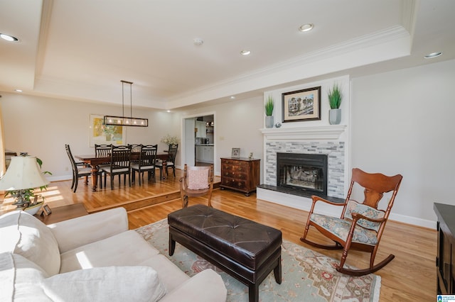 212 Bellbrook Dr, Cropwell, AL 35054 - living room with a raised ceiling, crown molding, a tiled fireplace, light wood finished floors, and recessed lighting