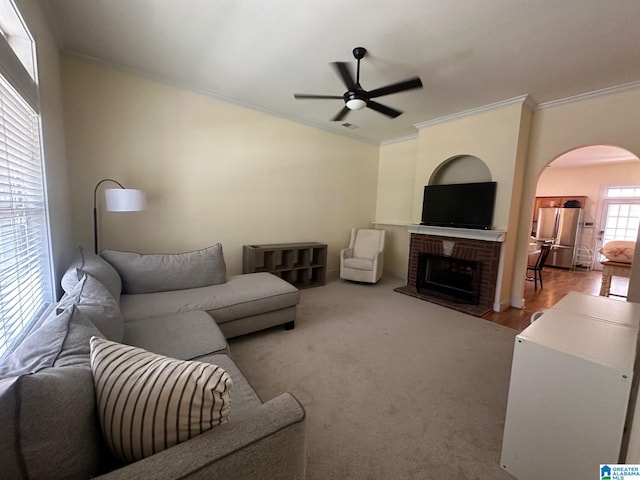 5433 Wisteria Trce, Trussville, AL 35173 - carpeted living area featuring ornamental molding, a ceiling fan, arched walkways, and a brick fireplace