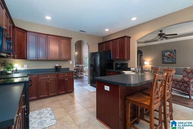 214 Quail Ridge Rd, Helena, AL 35080 - kitchen featuring arched walkways, black appliances, dark countertops, ceiling fan, and a breakfast bar