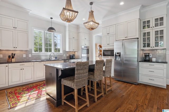 1528 Wellington Rd, Homewood, AL 35209 - kitchen featuring stainless steel appliances, a chandelier, tasteful backsplash, glass insert cabinets, and white cabinetry