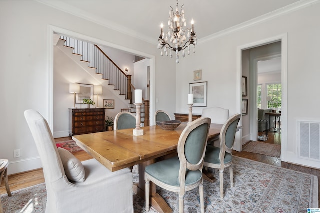 1528 Wellington Rd, Homewood, AL 35209 - dining room featuring ornamental molding, a chandelier, wood finished floors, and stairs