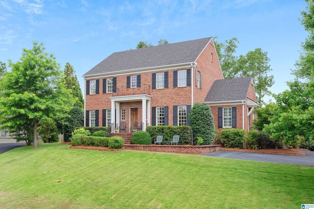 1528 Wellington Rd, Homewood, AL 35209 - colonial house with brick siding, a front lawn, and a shingled roof