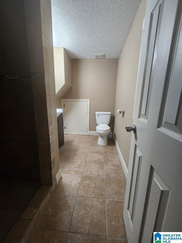 2030 Carraway St, Birmingham, AL 35235 - full bathroom featuring vanity, a textured ceiling, stone finish flooring, and tiled shower