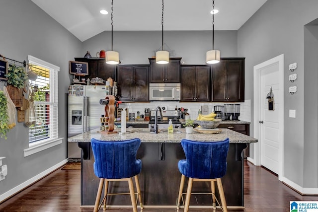 2165 Overlook Pl, Trussville, AL 35173 - kitchen with stainless steel stove, backsplash, a kitchen breakfast bar, dark brown cabinetry, and light stone counters