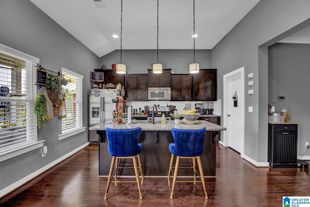 2165 Overlook Pl, Trussville, AL 35173 - kitchen with appliances with stainless steel finishes, dark brown cabinets, backsplash, a kitchen bar, and a kitchen island with sink