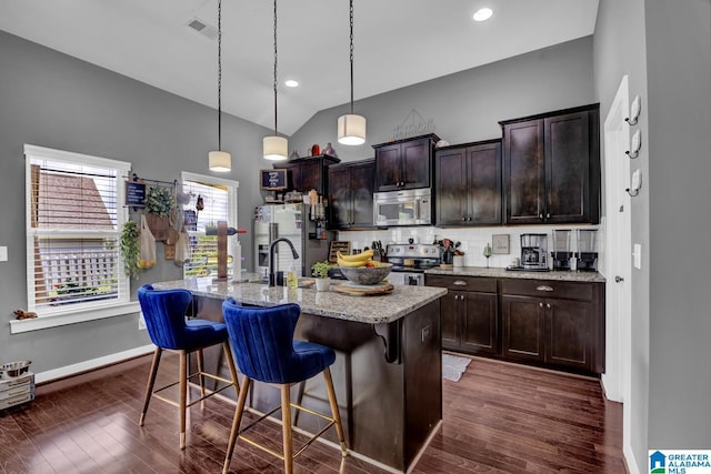 2165 Overlook Pl, Trussville, AL 35173 - kitchen featuring appliances with stainless steel finishes, dark wood-style flooring, lofted ceiling, a breakfast bar, and a center island with sink