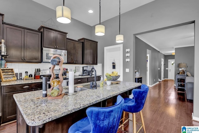 2165 Overlook Pl, Trussville, AL 35173 - kitchen with decorative backsplash, a kitchen bar, dark wood-type flooring, dark brown cabinetry, and a high ceiling