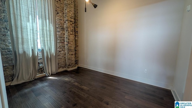 1801 2nd Ave N Unit 406, Birmingham, AL 35203 - empty room featuring dark wood-style flooring, healthy amount of natural light, ceiling fan, and brick wall